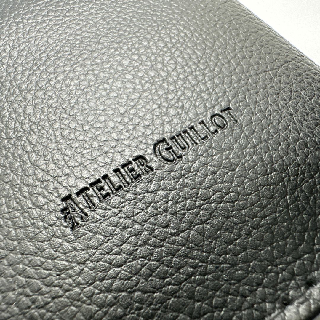 Logo atelier guillot sur un porte carte grise en simili cuir