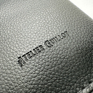 Logo atelier guillot sur un porte carte grise en simili cuir