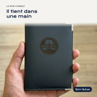 Porte-carte grise Aixam en simili cuir tenu dans une main