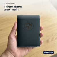 Porte-carte grise BMW en simili cuir tenu dans une main