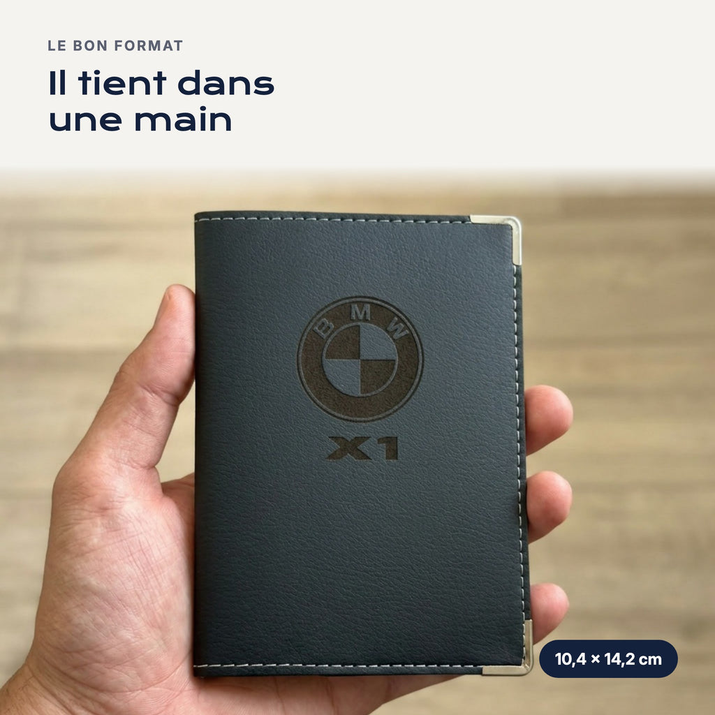 Porte-carte grise BMW X1 en simili cuir tenu dans une main