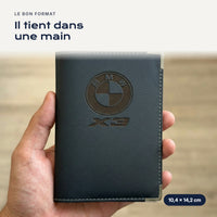 Porte-carte grise BMW X3 en simili cuir tenu dans une main