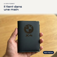 Porte-carte grise BMW X4 en simili cuir tenu dans une main