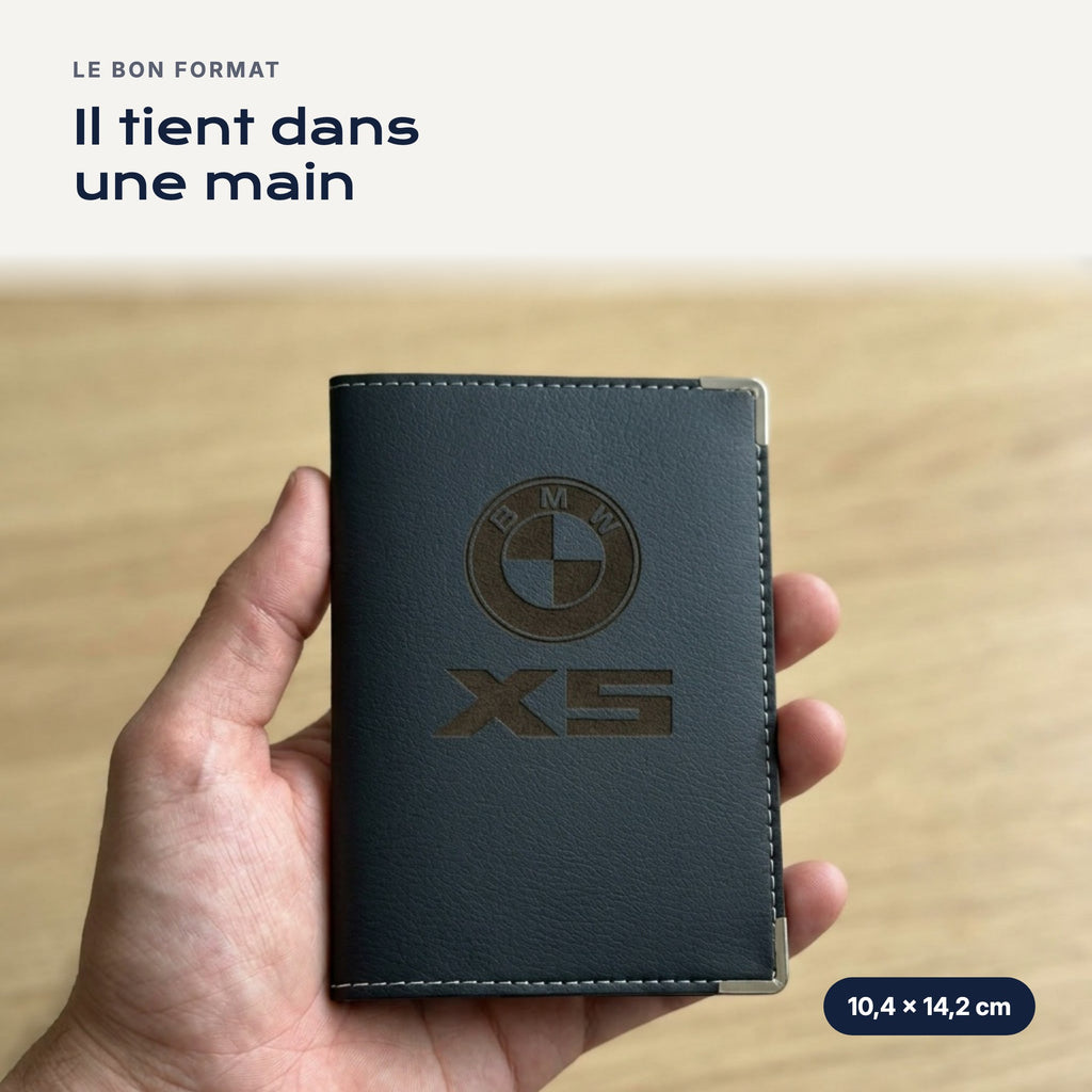 Porte-carte grise BMW X5 en simili cuir tenu dans une main