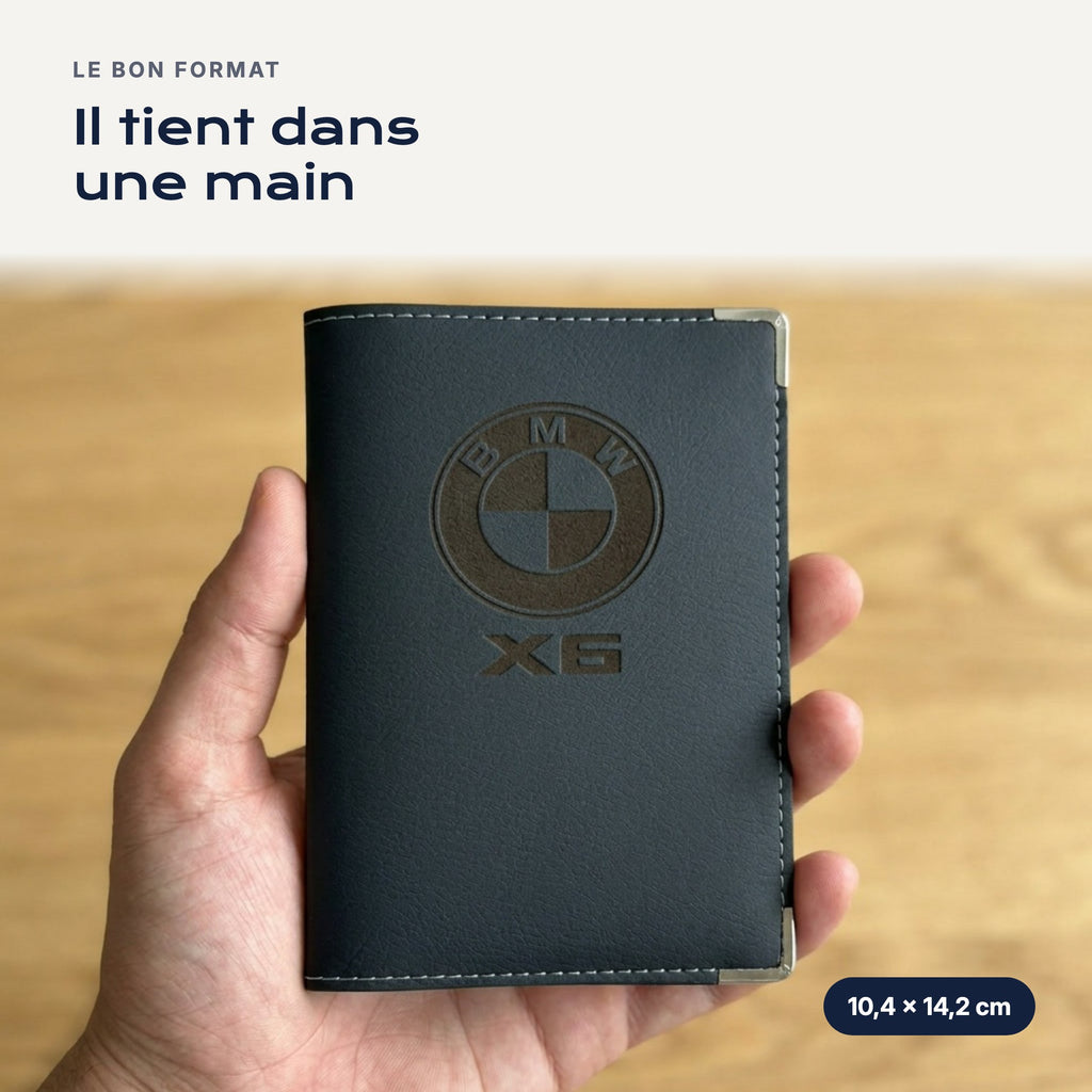 Porte-carte grise BMW X6 en simili cuir tenu dans une main