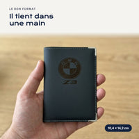 Porte-carte grise BMW Z3 en simili cuir tenu dans une main