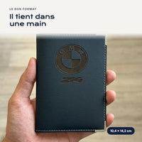 Porte-carte grise BMW Z4 en simili cuir tenu dans une main