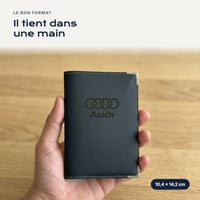 Porte-carte grise Audi en simili cuir tenu dans une main
