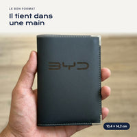 Porte-carte grise BYD en simili cuir tenu dans une main