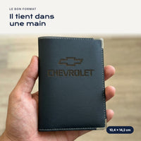 Porte-carte grise Chevrolet en simili cuir tenu dans une main