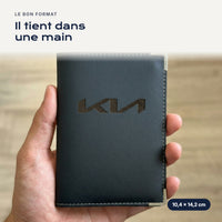 Porte-carte grise Kia en simili cuir tenu dans une main