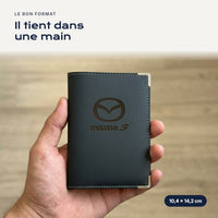 Porte-carte grise Mazda 3 en simili cuir tenu dans une main