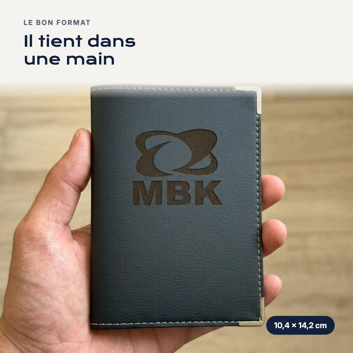 Porte-carte grise MBK en simili cuir tenu dans une main