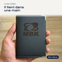 Porte-carte grise MBK en simili cuir tenu dans une main
