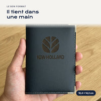 Porte-carte grise New Holland en simili cuir tenu dans une main