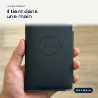 Porte-carte grise Nissan en simili cuir tenu dans une main