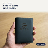 Porte-carte grise Opel en simili cuir tenu dans une main