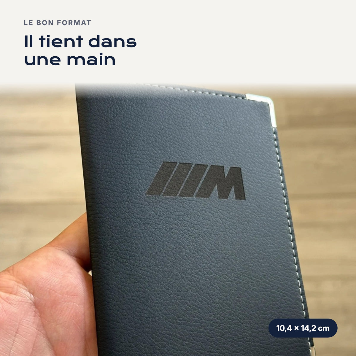 Porte-carte grise Pack M en simili cuir tenu dans une main