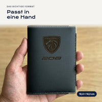 Fahrzeugscheinhülle Peugeot 208 aus Kunstleder in einer Hand