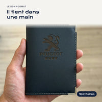 Porte-carte grise Peugeot GTI en simili cuir tenu dans une main