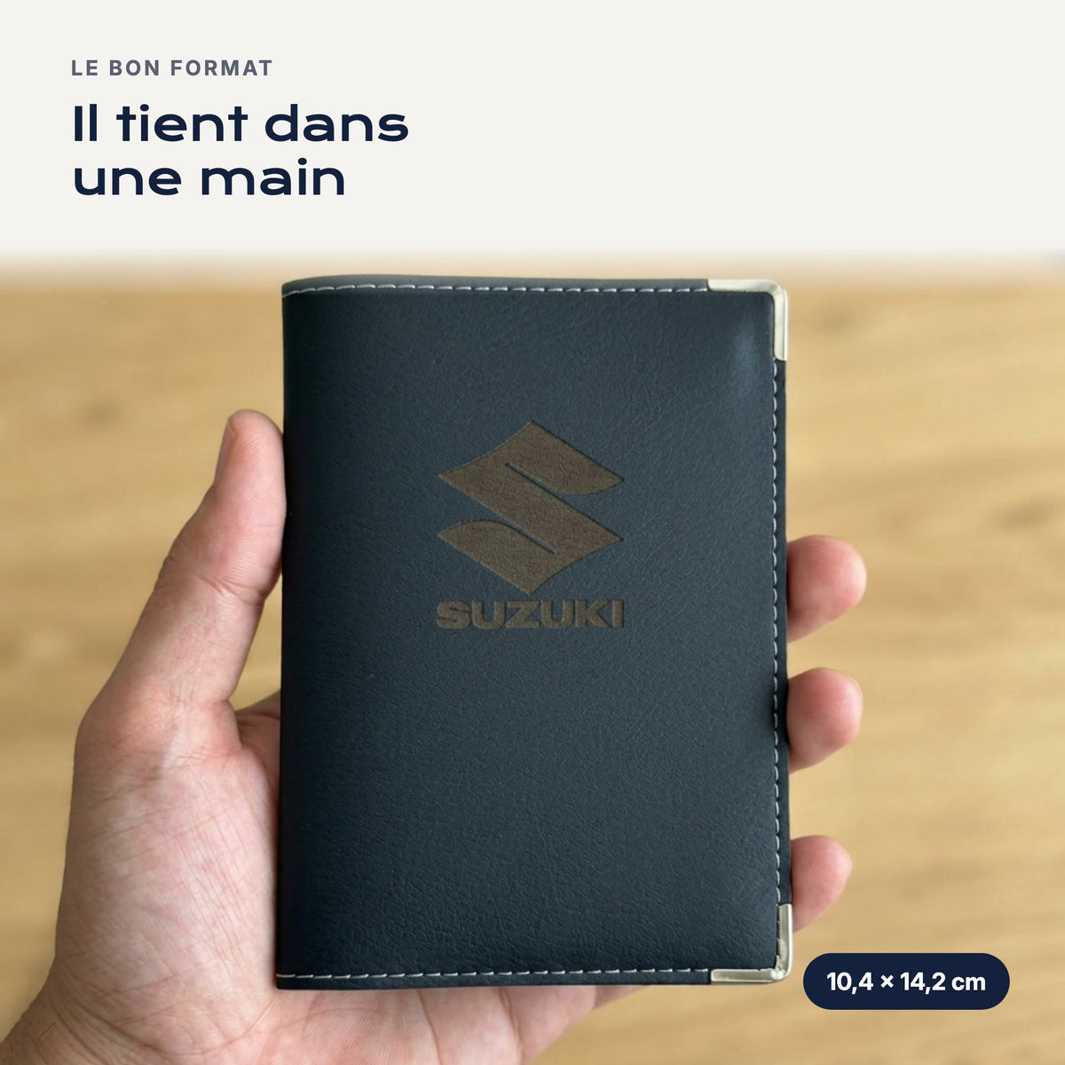 Porte-carte grise Suzuki en simili cuir tenu dans une main