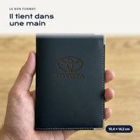Porte-carte grise Toyota en simili cuir tenu dans une main