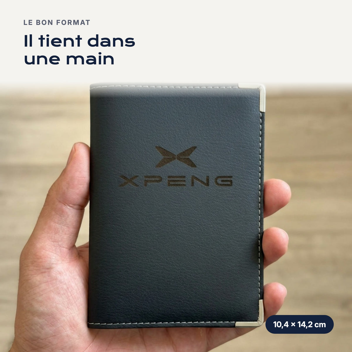Porte-carte grise Xpeng en simili cuir tenu dans une main