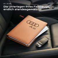 Fahrzeugmappe Audi A5 auf einem Autositz, mit Rechnungen