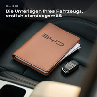 Fahrzeugmappe BYD auf einem Autositz, mit Rechnungen