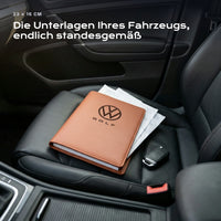 Fahrzeugmappe Volkswagen Golf auf einem Autositz, mit Rechnungen